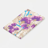 Lebhaftes Blumenmuster mit lila und blauem f Post-it Klebezettel (angewinkelt)