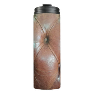 Leicht auf brauner Ledersofa-Oberfläche, textureab Thermosbecher