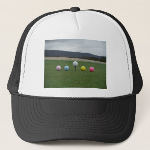 leuchtend farbige Golfbälle auf einem Berg Truckerkappe