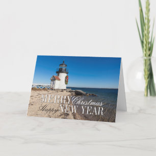 Leuchtturm am Strand mit einem Weihnachtskranz Feiertagskarte