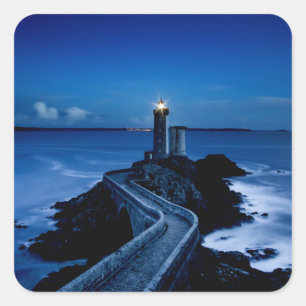 Leuchtturm an der Wand im Ozean in der Nacht Quadratischer Aufkleber