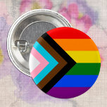 LGBTQ & Stolz - Regenbogen-Fortschrittsflagge Button<br><div class="desc">Button: Die Regenbogenflagge und die Variation "Progress" fügen einen Zickzack entlang des Hüftgeländes hinzu, der schwarze, braune, hellblaue, rosa und weiße Streifen aufweist, um diese Gemeinschaften (farbige Randgruppen, Transmenschen, HIV/AIDS-Infizierte und verloren gegangene Menschen) in den Vordergrund zu rücken. "Der Pfeil zeigt rechts hin, um Vorwärtsbewegung zu zeigen, während er am...</div>