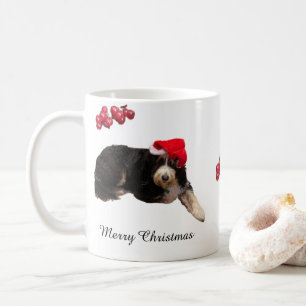 Lieblicher Hund mit einer Weihnachtsmannmütze an e Kaffeetasse