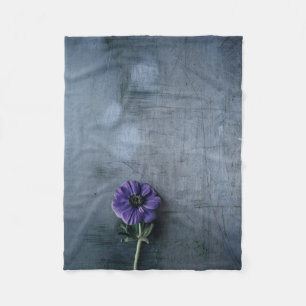 Lila gebogene Blume auf grauer Oberfläche Fleecedecke