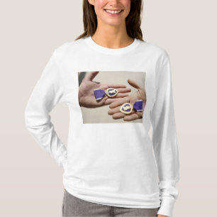 Lila Herzempfänger zeigen ihre Medaillen an T-Shirt