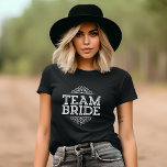 Lila und weiße Niedliche Teambridaktion Hochzeitsg T-Shirt<br><div class="desc">Niedlich angesagter Chic Girly Modern Elegantes Typografie Design Reads "Team Bride" mit Extravagantem Scroll Frame Border. Perfektes Geschenk für Braut, Brautjungfrauen und Hochzeitsfeier, um sich an Ihrem Hochzeitstag vorzubereiten! Klicken Sie auf die Schaltfläche "Anpassen", um die Vorderseite mit Ihren Namen oder anderen benutzerdefinierten Text für ein wirklich einzigartiges Design zu...</div>