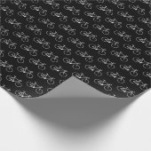 Lose weiße Fahrrad-Formen auf einem schwarzen Geschenkpapier (Ecke)