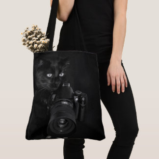 Lustige schwarze Katze mit der Kamera Tasche