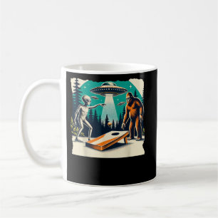 Lustiger Außerirdischer spielt Cornhole Bigfoot un Kaffeetasse