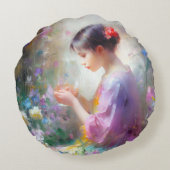 Mädchen bewundert eine Blume in ihren Händen Rundes Kissen (Rückseite)