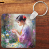 Mädchen bewundert eine Blume in ihren Händen Schlüsselanhänger (Rückseite)