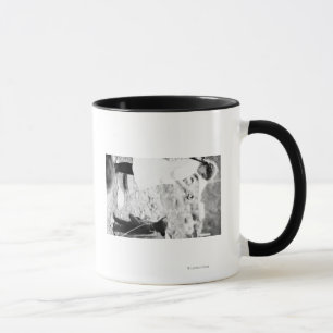 Mädchen, das Bärenjunges in Seward füttert Tasse