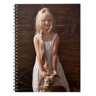 Mädchen in einer Scheune mit einem Kätzchen in ein Notizblock