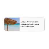Malerischer tropischer Strand mit Strohdach-Schirm (Vorne)