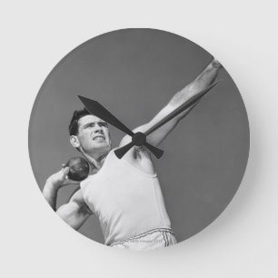 Man Throwing Shotput Runde Wanduhr