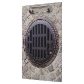 Manhole-Abdeckung und Kopfsteinpflasterstraße Klemmbrett (Links)