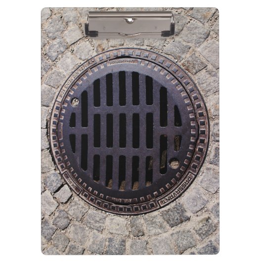 Manhole-Abdeckung und Kopfsteinpflasterstraße Klemmbrett (Vorderseite)