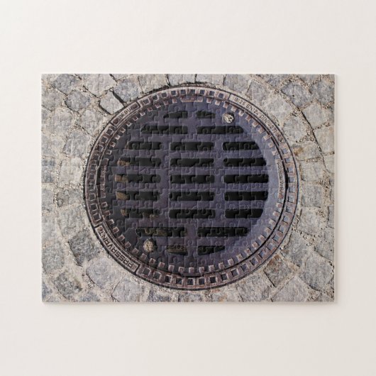 Manhole-Abdeckung und Kopfsteinpflasterstraße Puzzle (Horizontal)