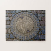 Manhole-Abdeckung und Kopfsteinpflasterstraße Puzzle (Horizontal)