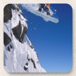 Mann auf einem Snowboard, der von einem Gesims am Getränkeuntersetzer
