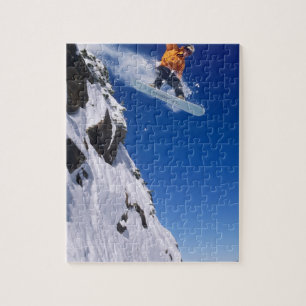 Mann auf einem Snowboard, der von einer Gesimskant Puzzle