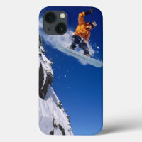 Mann auf einem Snowboard springt von einem Korn