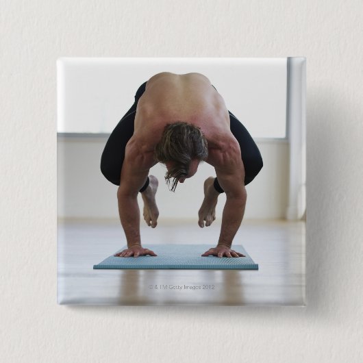 Mann, der an Yogamat arbeitet Button (Vorderseite)