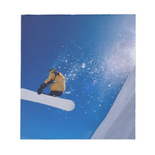 Mann, der auf einem Snowboard durch die Luft flieg Notizblock