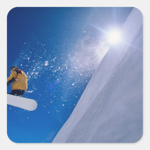Mann, der auf einem Snowboard durch die Luft flieg Quadratischer Aufkleber