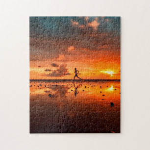 Mann, der bei Sunset am Strand läuft Puzzle