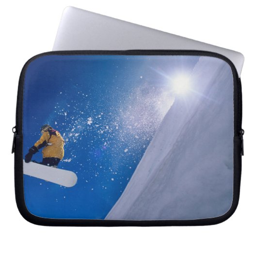 Mann, der mit einem Snowboard durch die Luft flieg Laptopschutzhülle (Vorderseite)