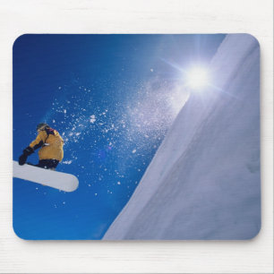 Mann, der mit einem Snowboard durch die Luft flieg Mousepad