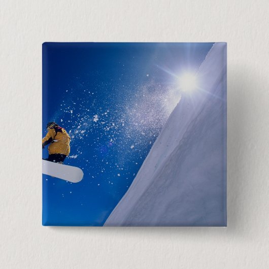 Mann fliegt auf einem Snowboard durch die Luft mit Button (Vorderseite)