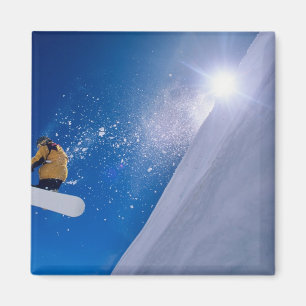 Mann fliegt auf einem Snowboard durch die Luft mit Magnet
