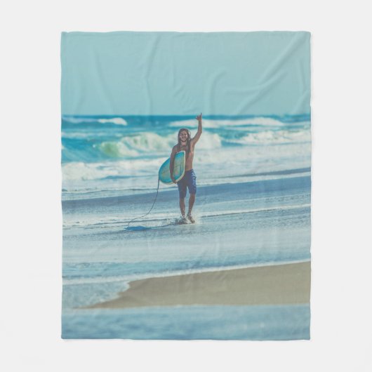 Mann mit Surfbrett am Strand Fleecedecke (Vorderseite)