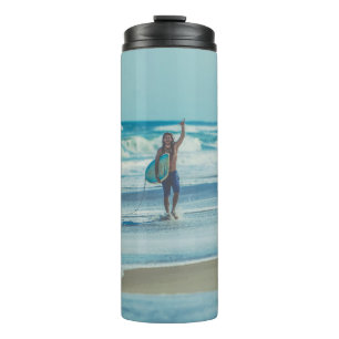 Mann mit Surfbrett am Strand Thermosbecher