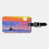 Mann sieht sich das Gepäckanhänger bei Sonnenunter (Vorderseite horizontal)