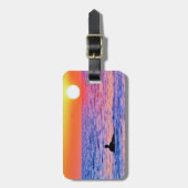 Mann sieht sich das Gepäckanhänger bei Sonnenunter (Vorderseite vertikal)