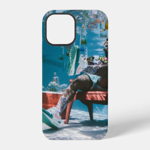 Mann sitzt auf Stuhl unter Wasser mit schwimmender iPhone 12 Hülle