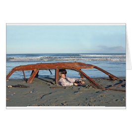 Mann sitzt in einem rostigen Auto am Strand