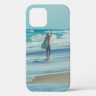 Mann trägt Surfbrett am Strand iPhone 12 Hülle