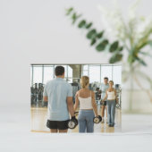 Mann und Frau heben Handgewichte vor einem Postkarte (Stehend Vorderseite)