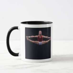 Männlicher Gymnast darstellend auf der Bodenübung Tasse