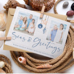 Meer und Grüße Küstenwald Holiday Foto Feiertagskarte<br><div class="desc">Seas and Greetings Seashell Ornament on Coastal Wood Holiday Foto Weihnachtskarten mit Ozeanblau und sandige tan Muschel Ornamente hängen von Segeljute Seil auf Küstenschiffholz mit eleganten Typografie. Fügen Sie zwei Ihrer Fotos und eine persönliche Nachricht für eine lustige nautische Urlaubskarte hinzu. Bitte kontaktieren Sie uns unter cedarandstring@gmail.com , wenn Sie...</div>