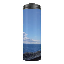 Meeresufer und Bahngleis unter blauem Himmel