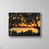 Menschen am Ufer bei Sonnenuntergang Leinwanddruck (Vorderseite)