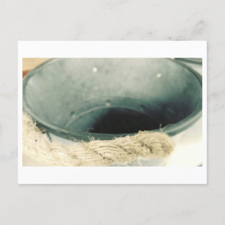 Metalldose auf Bauernhof mit Seil Postkarte