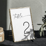 Minimalistische Schwarz-Weiß-Moderne Skripthochzei Tischnummer<br><div class="desc">Mit dieser minimalistisch-schwarz-weißen Tischnummer mit eleganter Schriftzeichen verleihen Sie Ihrem Hochzeitsdekor eine fröhliche Note. Das Design bietet eine saubere und moderne Ästhetik und macht es zu einer vielseitigen Wahl für verschiedene Hochzeitsthemen, einschließlich zeitgenössischer, rustikaler oder klassischer Stile. Diese Tischnummer ist ideal für Paare, die ein raffiniertes und zeitloses Aussehen suchen,...</div>