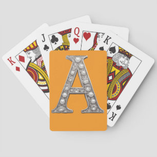 Mit Juwelen besetzter Buchstabe A auf gelbem Hinte Spielkarten