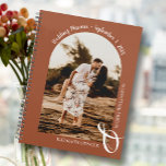 Modern Foto Parco Tassino Planer<br><div class="desc">Ein eleganter, spiralgebundener Hochzeitsplaner-Kalender zeigt Ihr Foto in einem einzigartigen Gewölbe auf Terrakotta-Hintergrund, Ihre Namen verbunden mit einem großen weißen Ampersand am unteren Ende und Ihr Hochzeitstermin gewölbt oben. Ändern Sie die Farbe des Buches auf der Vorderseite und wieder zurück, um Ihr Foto anzupassen. Der Live-Design-Service kann Ihnen bei Bedarf...</div>